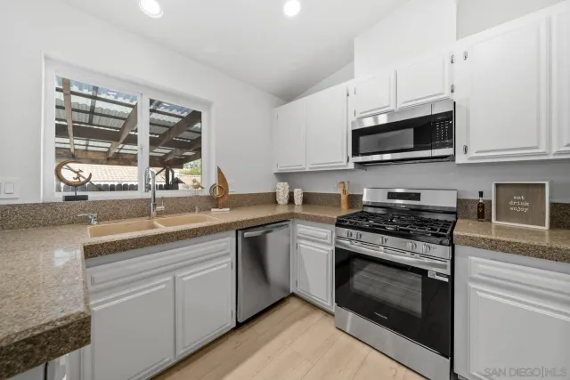a kitchen with stainless steel appliances granite countertop a sink a stove and microwave