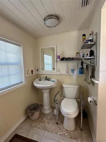 a bathroom with a toilet sink and mirror