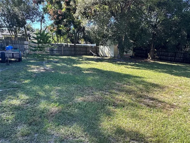 a view of swimming pool with lawn chairs and wooden fence