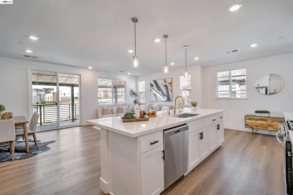 a kitchen that has a lot of cabinets and wooden floor