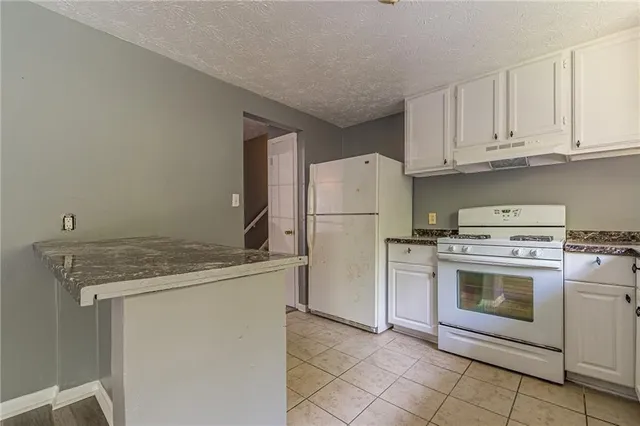 a kitchen with a stove top oven and refrigerator