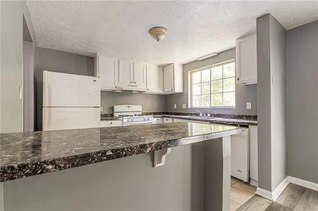 a kitchen with a refrigerator a stove a sink and a window