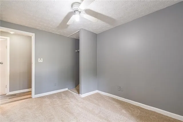 an empty room with a fan & a fan