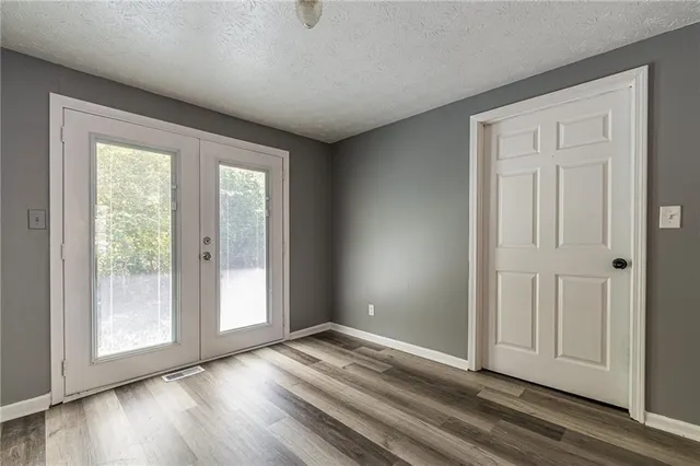 an empty room with wooden floor and windows