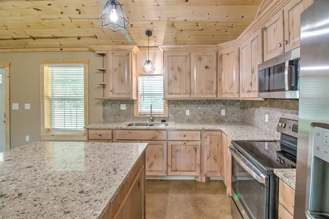 a kitchen with stainless steel appliances granite countertop a sink stove and cabinets
