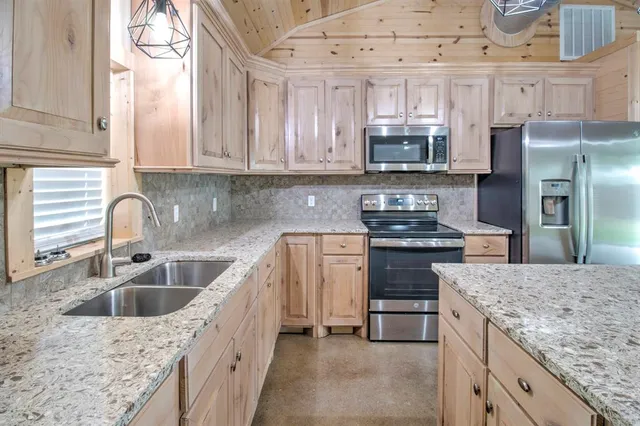 a kitchen with stainless steel appliances granite countertop a sink stove and refrigerator