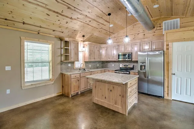 a kitchen with refrigerator cabinets and windows