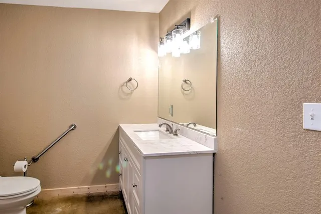 a bathroom with a sink and mirror with toilet