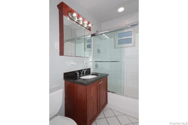 a bathroom with a sink a toilet and mirror