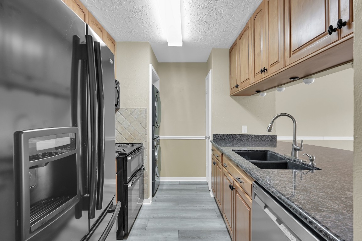 801 River Road, Unit 123F Montgomery, TX 77356 - Photo 14 of 32 a kitchen with stainless steel appliances granite countertop a refrigerator and a sink