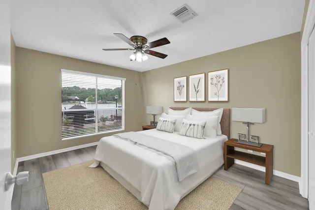 a bedroom with a large bed and a chandelier