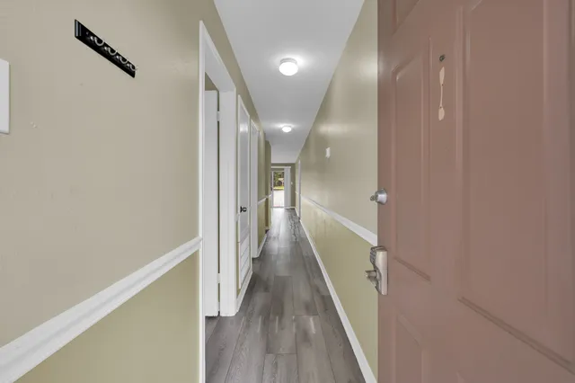 a view of a hallway with wooden floor