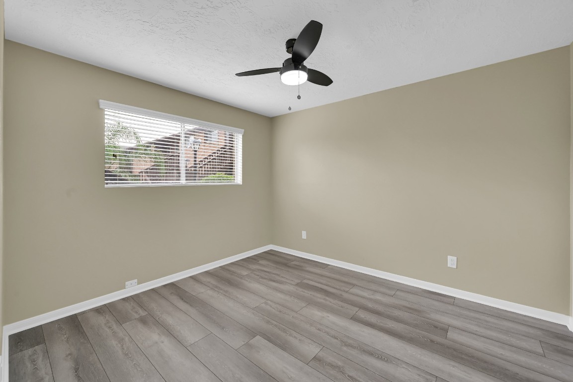 801 River Road, Unit 123F Montgomery, TX 77356 - Photo 9 of 32 an empty room with wooden floor and ceiling fan