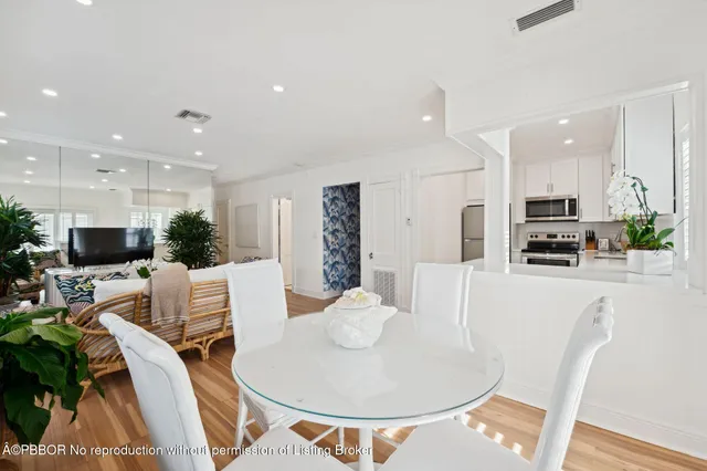 a living room with furniture a flat screen tv and kitchen view