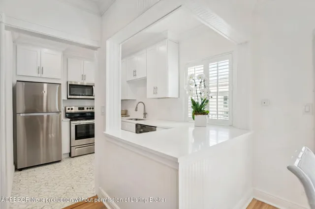 a kitchen with stainless steel appliances a sink a stove a microwave and a refrigerator