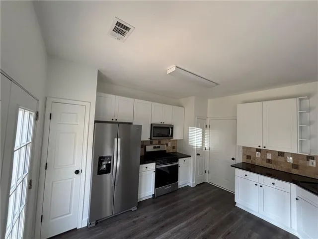 a kitchen with granite countertop a refrigerator and a sink