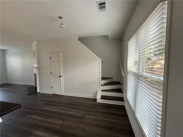 a view of a livingroom with wooden floor and stairs