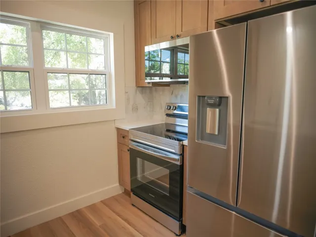 a kitchen with stainless steel appliances a refrigerator and a window