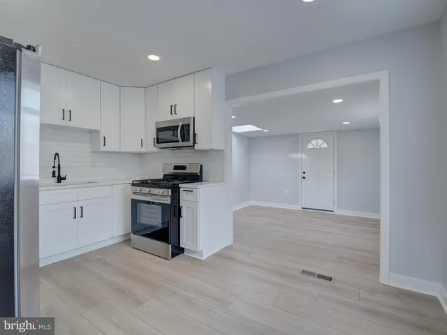 a kitchen with granite countertop a stove a sink and a refrigerator