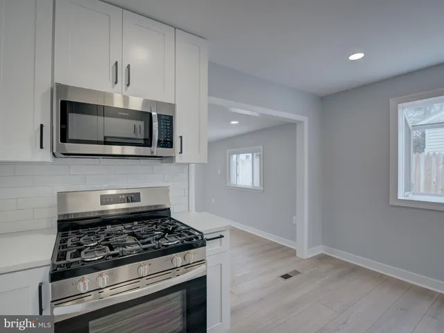 a kitchen with stainless steel appliances a stove a microwave and cabinets
