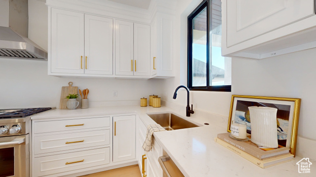 657 North Heritage Street, Unit 9 Mapleton, UT 84664 - Photo 5 of 10 Kitchen with wall chimney range hood, stainless steel stove, white cabinetry, and light stone countertops