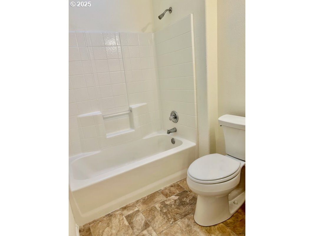 402 Sherwood Loop Florence, OR 97439 - Photo 17 of 33 a bathroom with a toilet and a bathtub