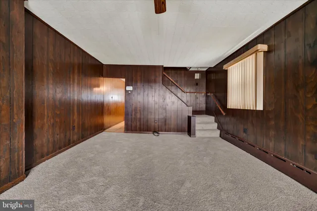 a view of a livingroom with wooden floor and staircase