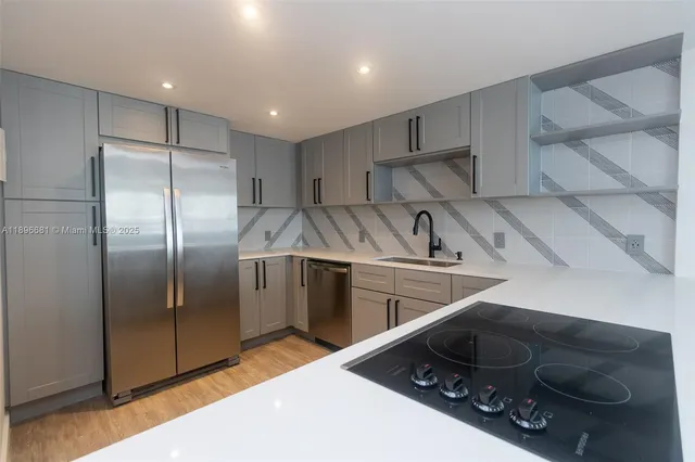 a kitchen with stainless steel appliances granite countertop a sink and a refrigerator