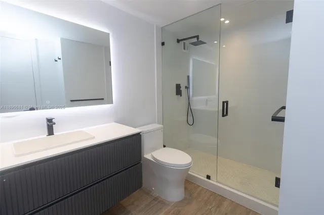 a bathroom with a sink a toilet and shower