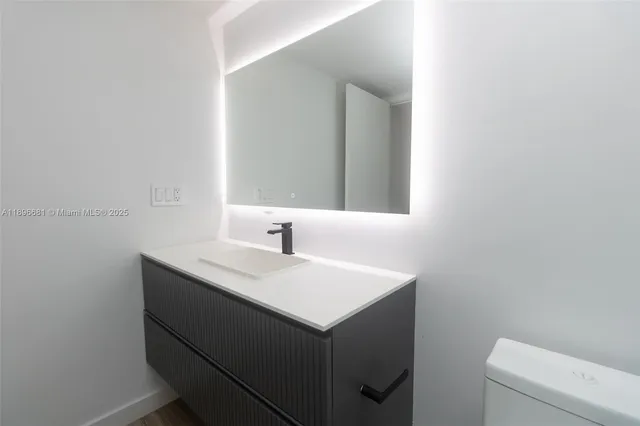 a bathroom with a sink toilet and mirror