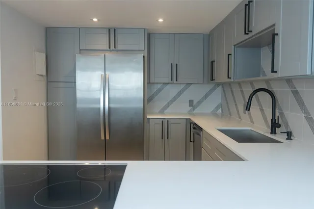 a kitchen with stainless steel appliances granite countertop a sink a refrigerator and a granite counter tops