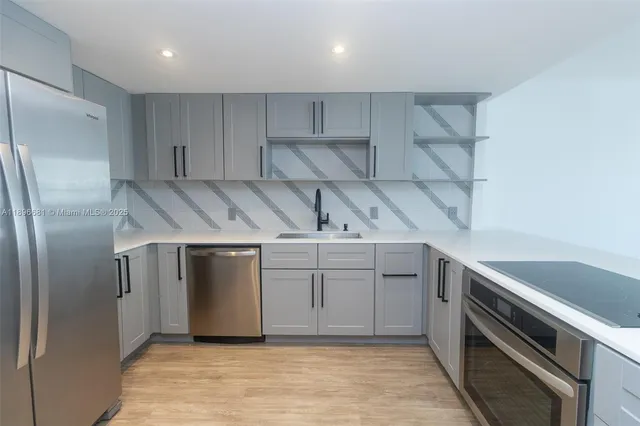 a kitchen with a sink stainless steel appliances and cabinets