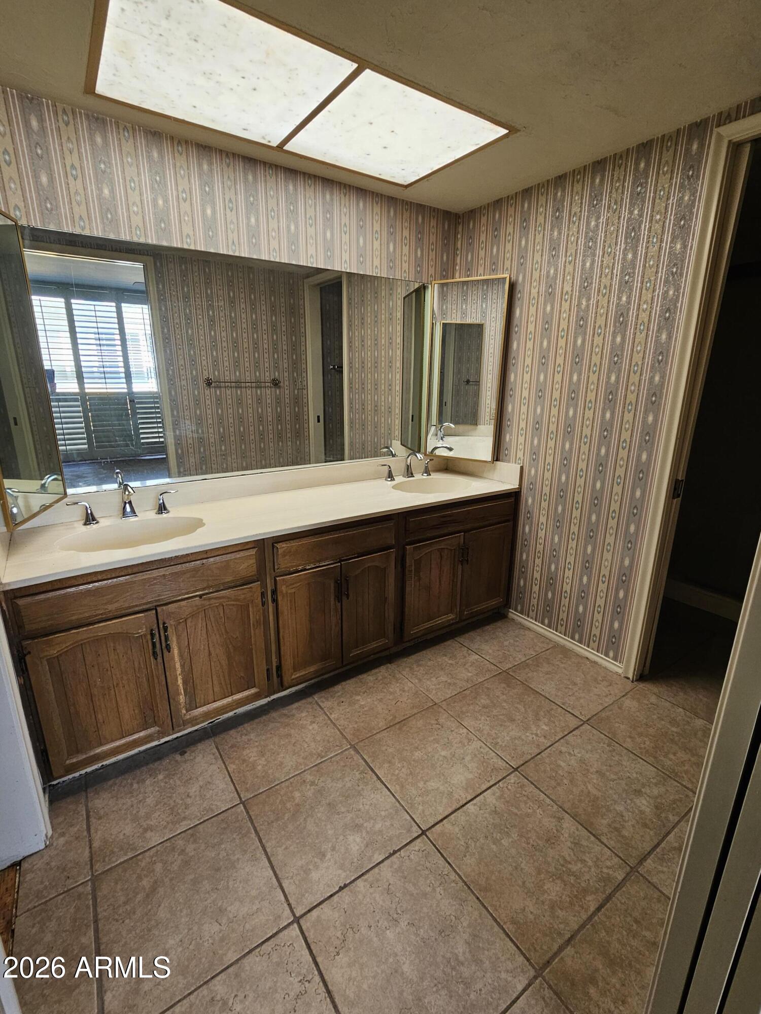 7003 North Barbados Place Phoenix, AZ 85021 - Photo 13 of 15 a bathroom with a sink a mirror and a bathtub