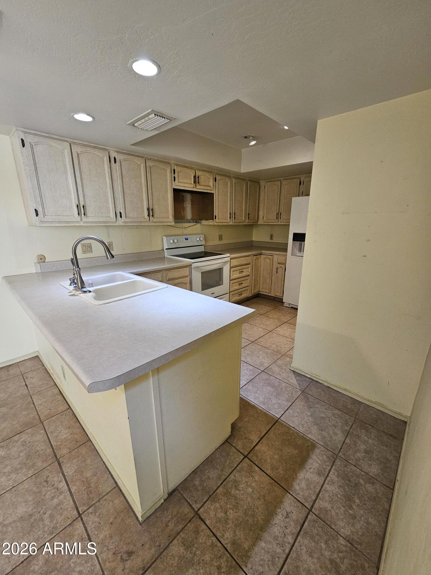 7003 North Barbados Place Phoenix, AZ 85021 - Photo 9 of 15 a kitchen with stainless steel appliances a sink a stove top oven a counter space and cabinets