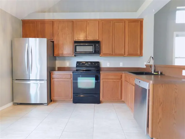 a kitchen with a refrigerator sink and stove