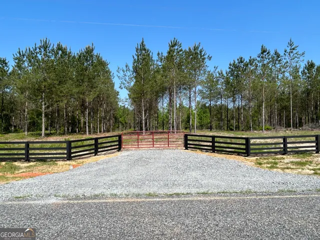 a view of a bench with trees in the background