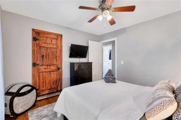 a bedroom with a bed and a flat tv screen on dresser