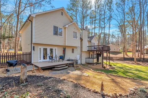 a view of a house with a wooden bench in a backyard
