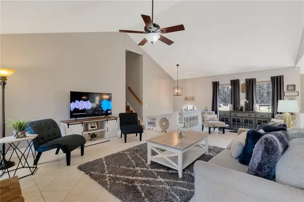 a living room with furniture a flat screen tv and a window