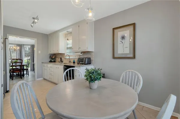 a kitchen with stainless steel appliances granite countertop a refrigerator a sink a stove and white cabinets