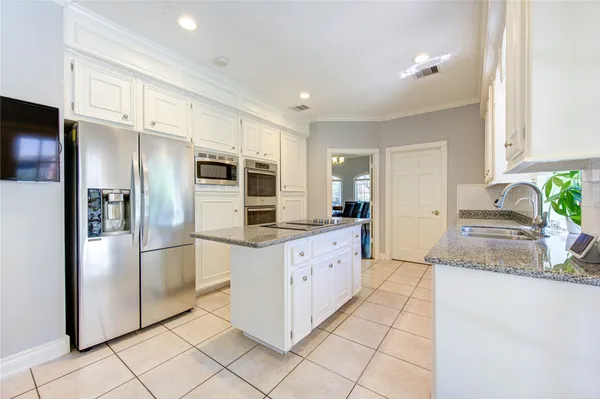 a kitchen with granite countertop a refrigerator and a sink