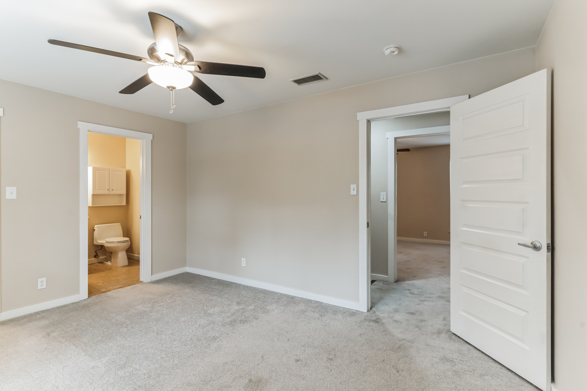 3214 Clawson Road, Unit A Austin, TX 78704 - Photo 10 of 26 A well-lit bedroom features plush carpet and an adjacent bathroom with a simple vanity.