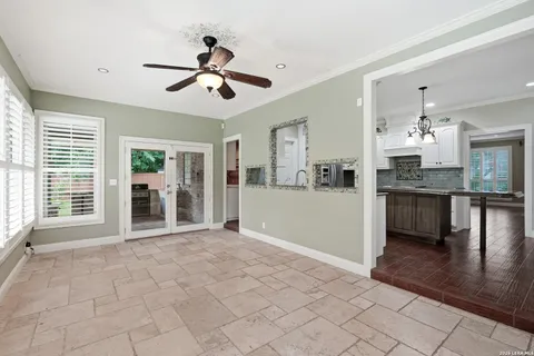 a view of an empty room with kitchen and window