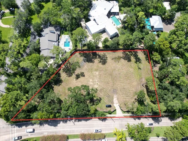 an aerial view of a house with a yard and greenery