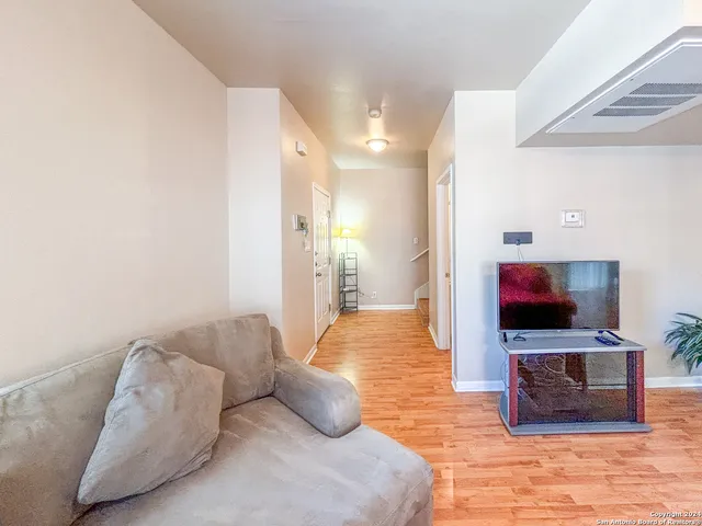 a bedroom with a bed and a flat tv screen on dresser