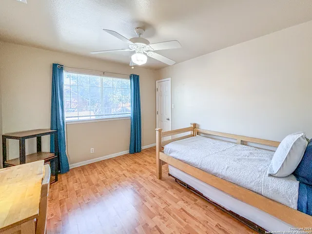 a spacious bedroom with a bed and a table with chair