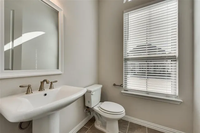 a bathroom with a sink a window and a toilet