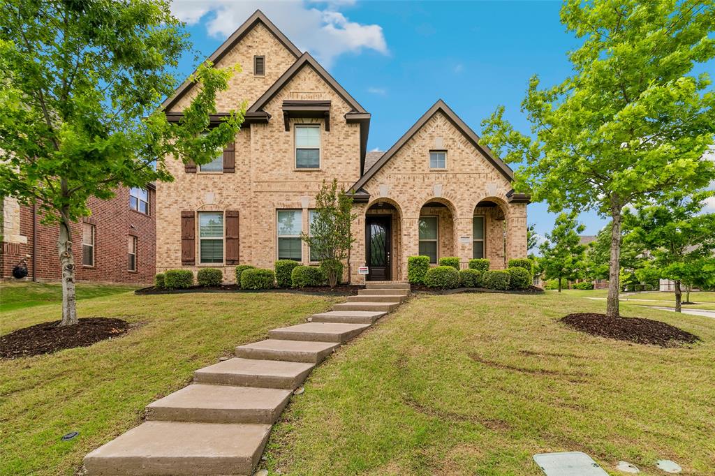 a front view of a house with a yard and trees