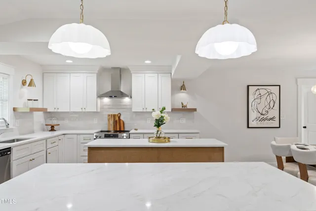 a view of kitchen with stainless steel appliances granite countertop a stove a sink a refrigerator white cabinets and wooden floor