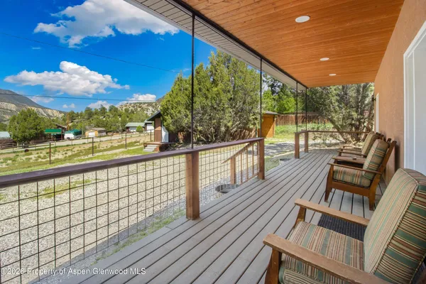 a view of balcony with wooden floor and seating space